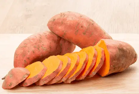 three sweet potatoes with one cut into slices