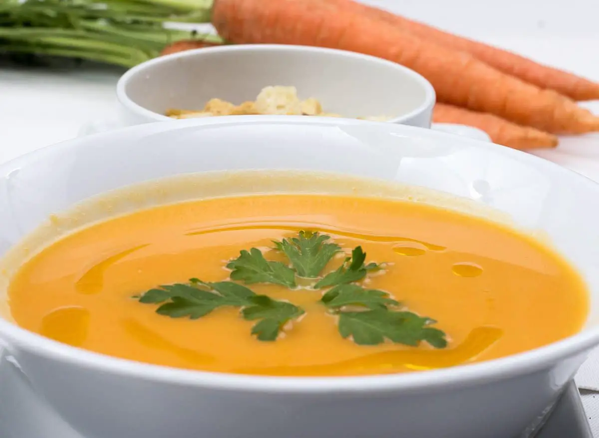 carrot soup bowl with carrots in the background